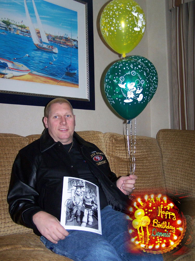 Dennis in our suite holding his balloons and autographed photo by a character, Woody he got upon check-in at the Paradise Pier Hotel.
