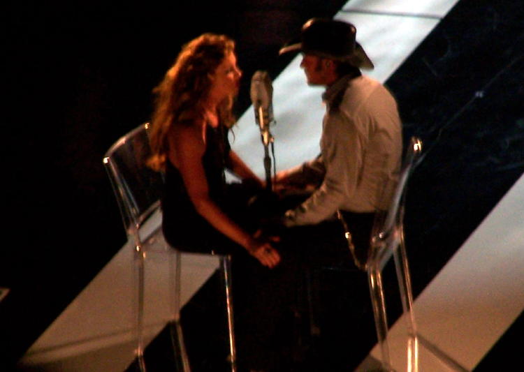 Faith Hill and Tim McGraw singing a song on stage during the taping for a 2-hour TV special