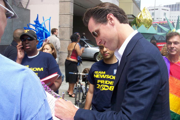 Mayor Gavin Newsom signing what appears to be a marriage certificate.