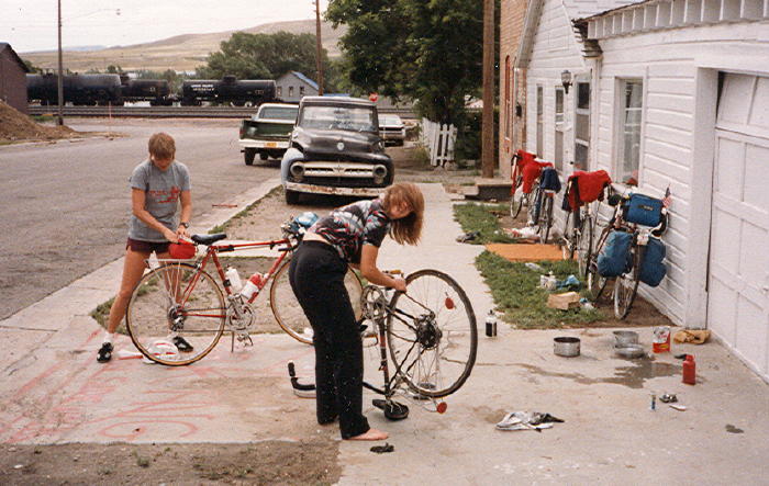 Pictured (left to right), Ann and Debbie are cleaning their bicycles in front of the house the group of us stayed in while in Rawlins, WY.